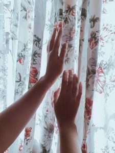 a hand while touching a curtain